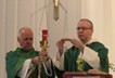 A
          group of men in green robes holding a candleAI-generated
          content may be incorrect.